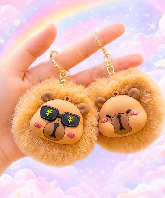 Two capybara plush keychains with rainbow background