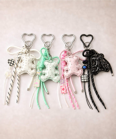 White, green, pink and black bear PU leather bag charm keychains with sparkle charms displayed together on a neutral background.