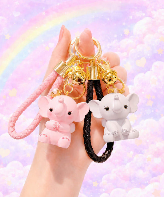 Pink and grey elephant keychains held in hand