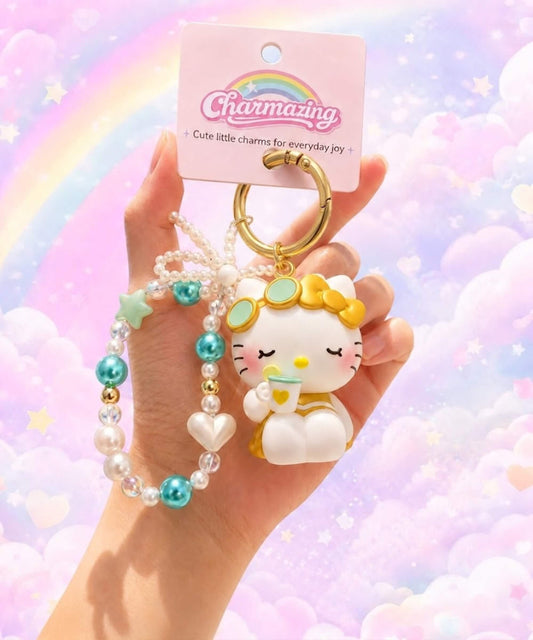 Hello Kitty tea Sanrio beaded keychain held in hand with pearl-look beads and CHARMAZING packaging