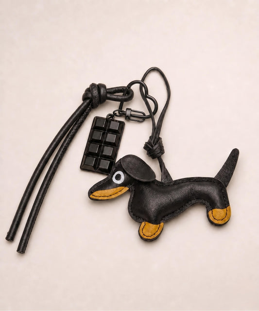 Black sausage dog PU leather bag charm keychain with a black chocolate charm styled on a neutral background.