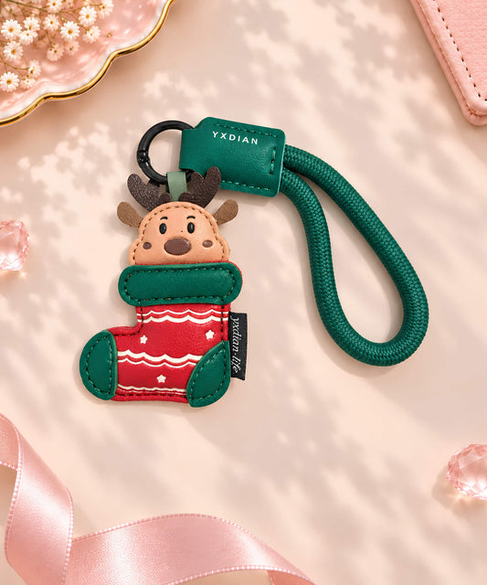 Reindeer Stocking Christmas PU leather bag charm keychain styled on a soft pink background