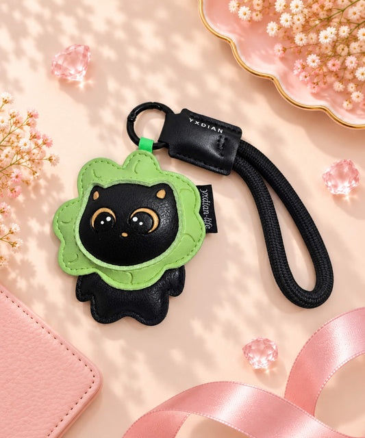 Floral black cat PU leather bag charm keychain styled on a soft pink background