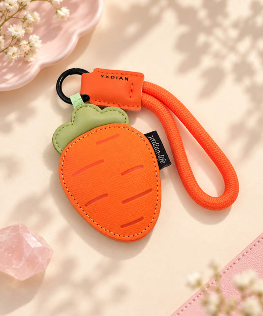 Orange carrot PU leather bag charm keychain styled on a warm neutral background