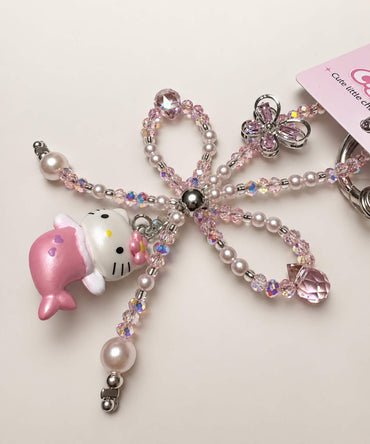Close-up of pink crystal-style beaded bow and butterfly detail on Hello Kitty Mermaid phone charm