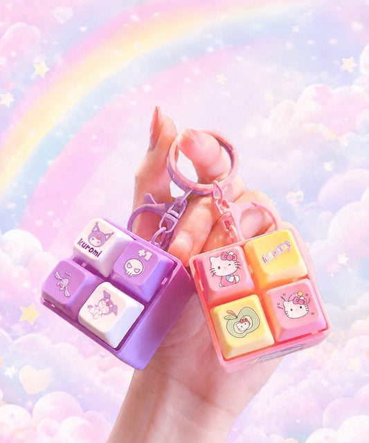 Light-up sound button keychains in Hello Kitty and Kuromi designs held by hand on a pastel rainbow background
