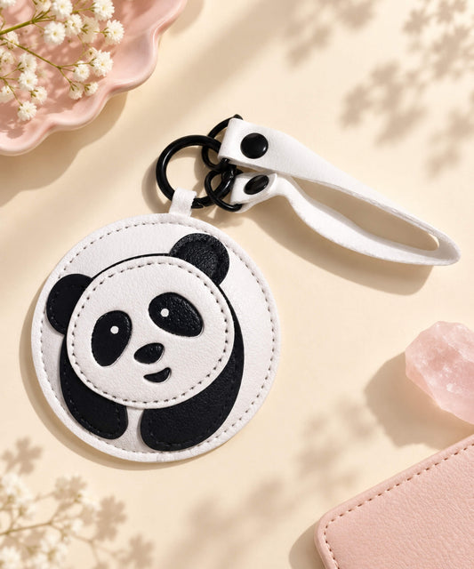 Round Panda PU leather bag charm keychain styled on a warm neutral background