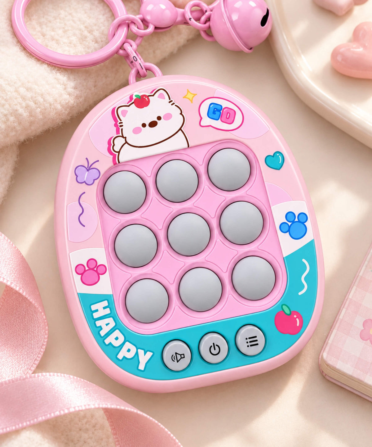 Pink 3-in-1 Tic Tac Toe game keychain styled with soft pink accessories