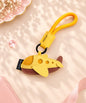 Yellow airplane PU leather bag charm keychain styled on a soft pink neutral background
