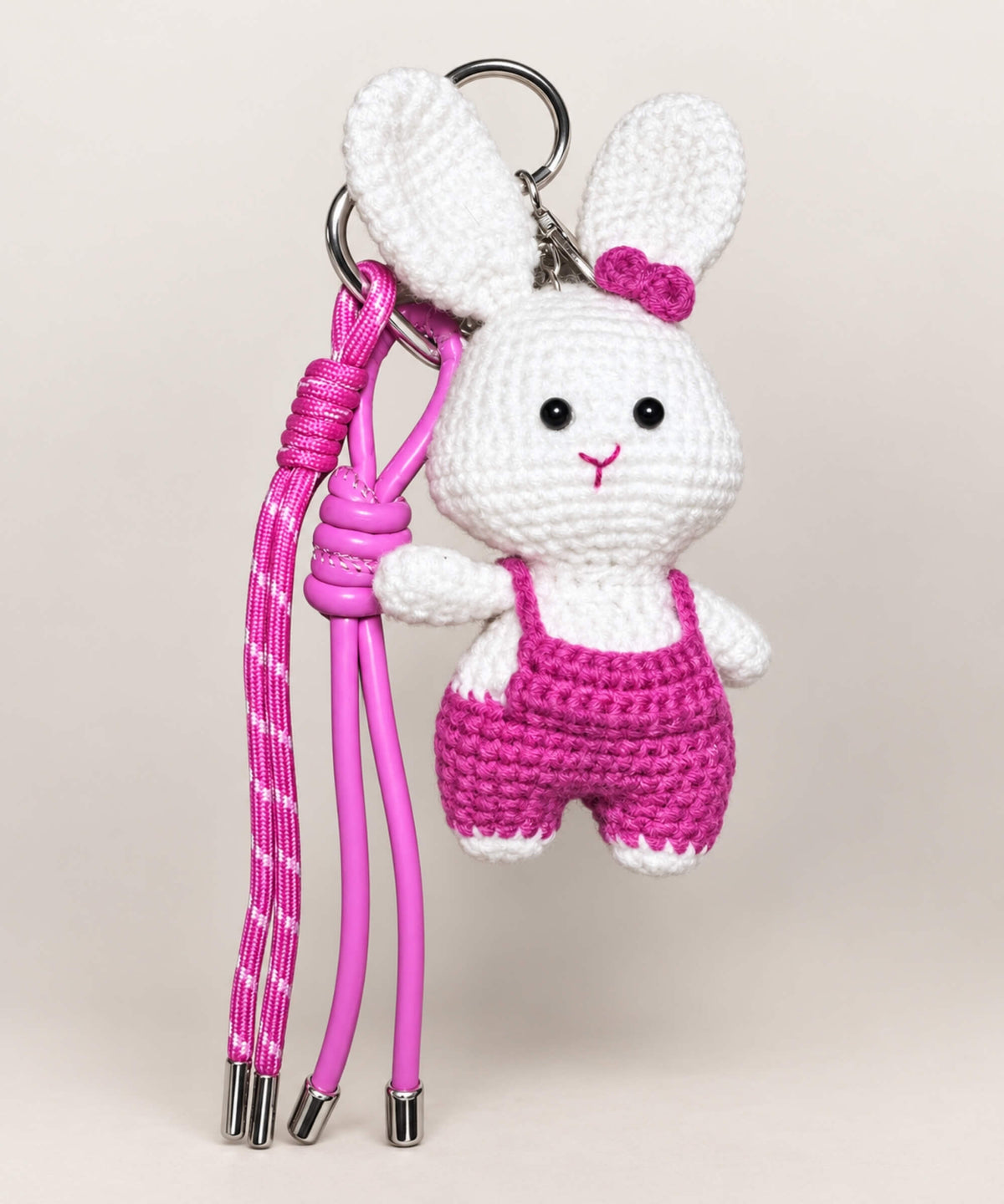 White bunny crochet keychain wearing pink overalls with pink hanging cords