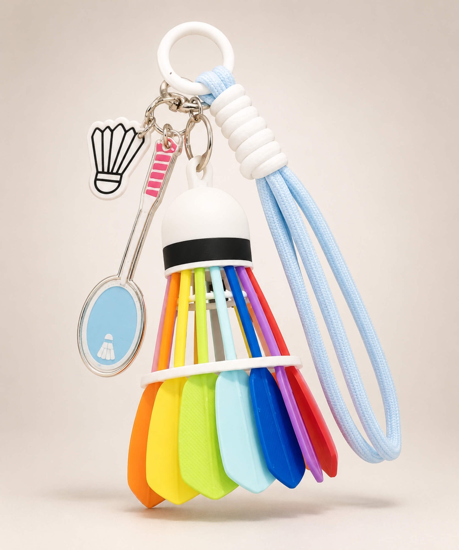 Baby blue badminton shuttlecock rope keychain with racket charm and shuttlecock charm on neutral background