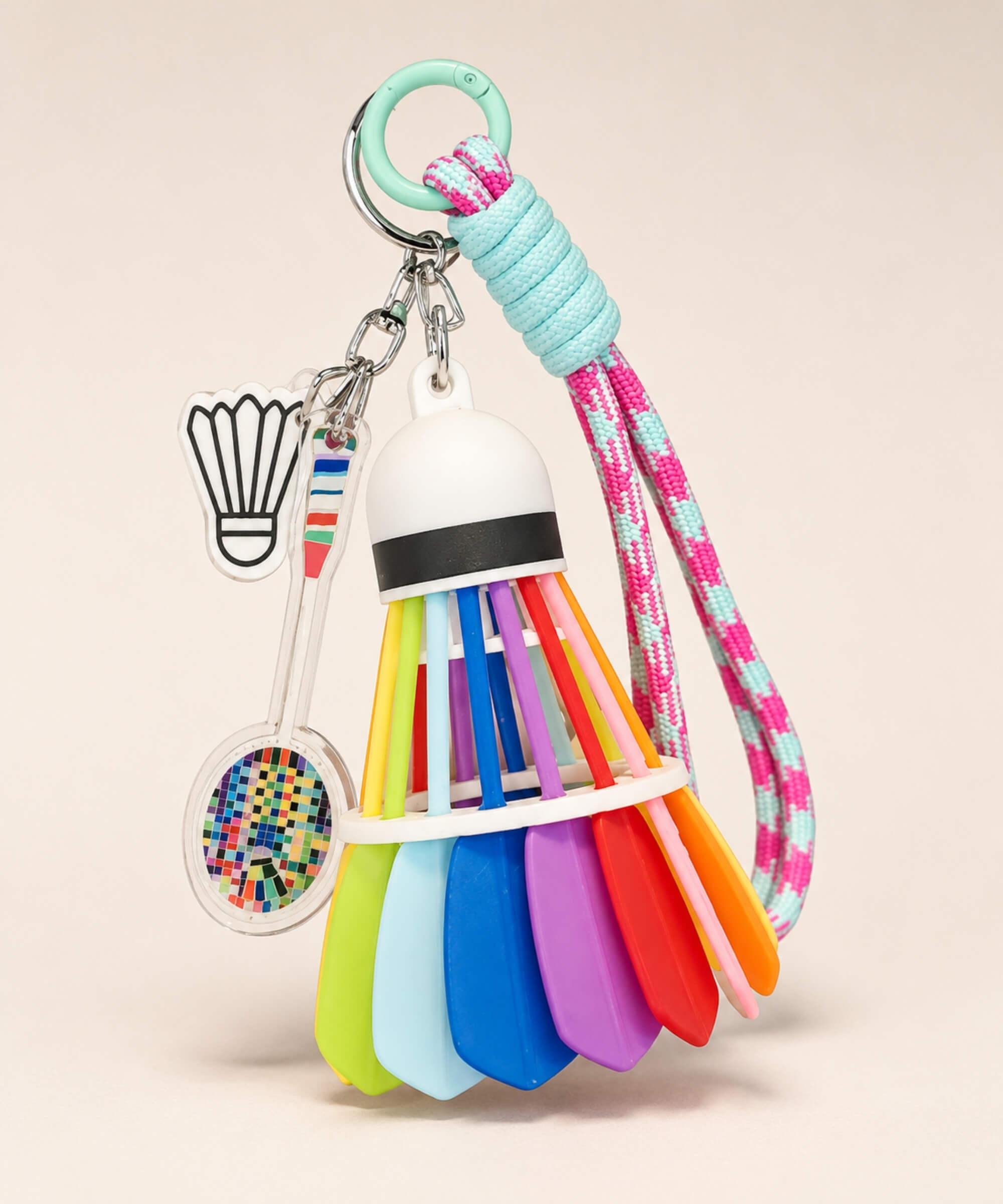 Pink and mint badminton shuttlecock rope keychain with racket charm and shuttlecock charm on neutral background