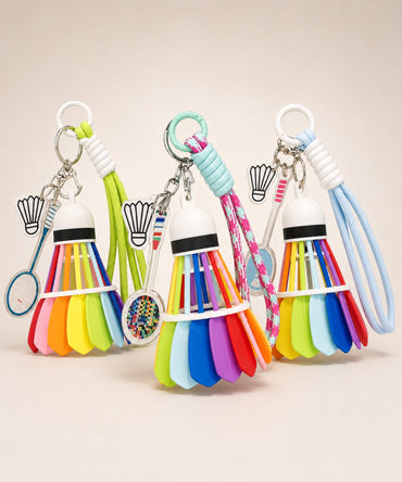 Three badminton shuttlecock rope keychains in pink, green and blue displayed together on a neutral background