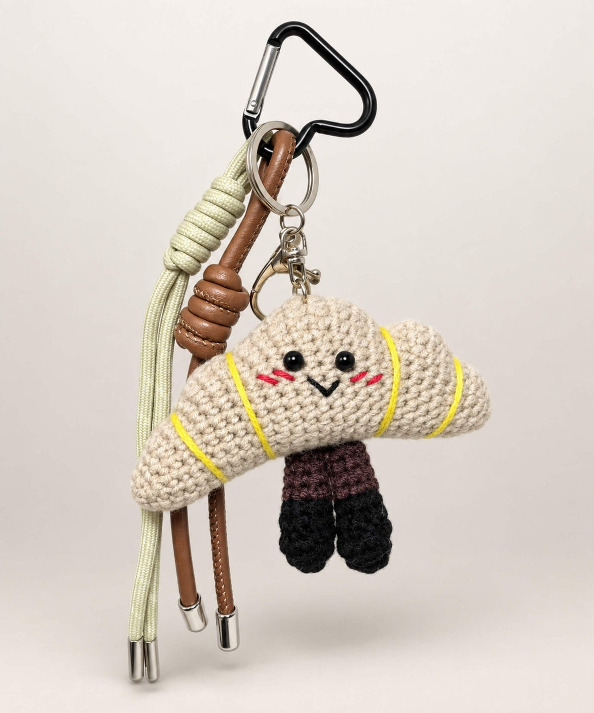 Cream croissant bakery crochet keychain with cute face and neutral brown straps
