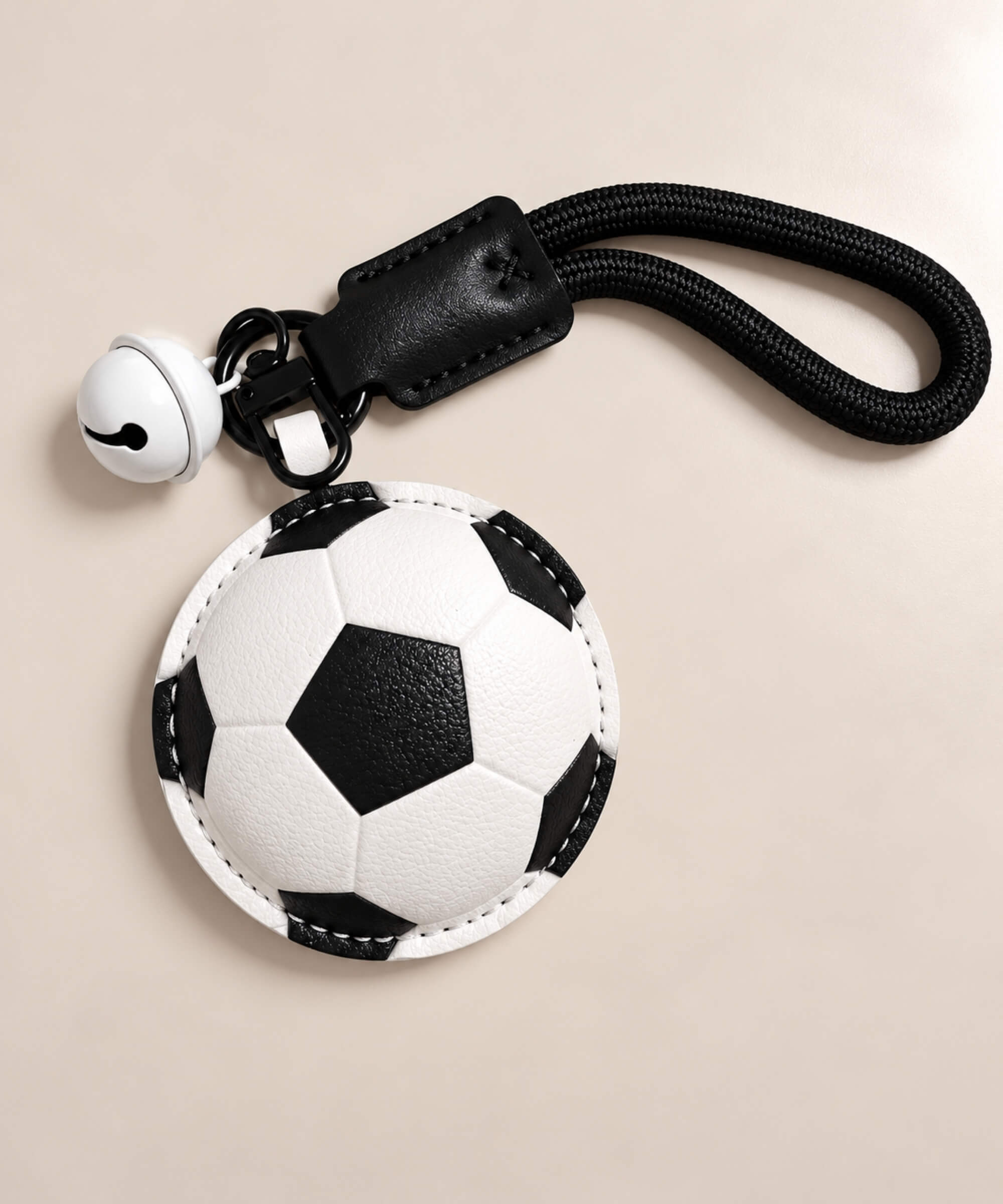 Football PU leather-look bag charm keychain styled on a warm neutral background
