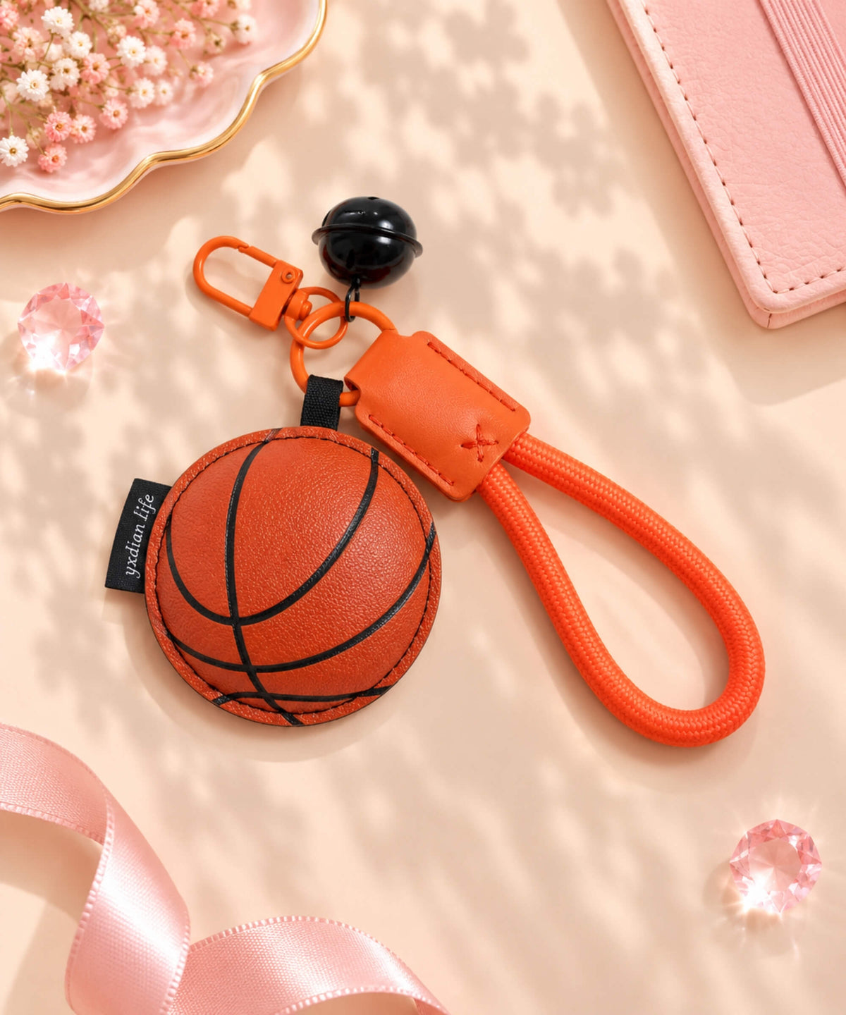 Basketball PU leather-look bag charm keychain styled on a warm neutral background