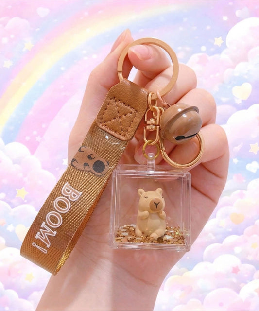 Cute capybara liquid shaker keychain in acrylic cube held in hand, floating glitter bag charm with kawaii aesthetic background