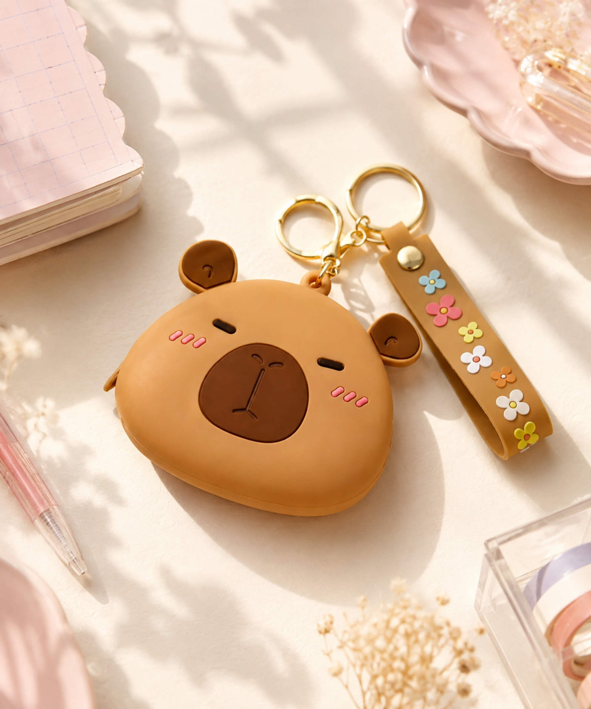 Brown capybara silicone coin purse keychain with cute face, floral wrist strap and gold-tone keyring