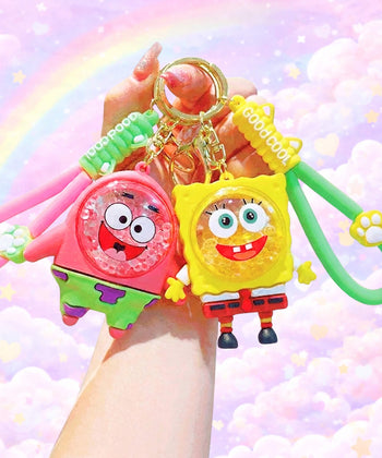 Cartoon sponge and star style bubble bead shaker keychains held in hand, cute colourful character bag charms with floating beads