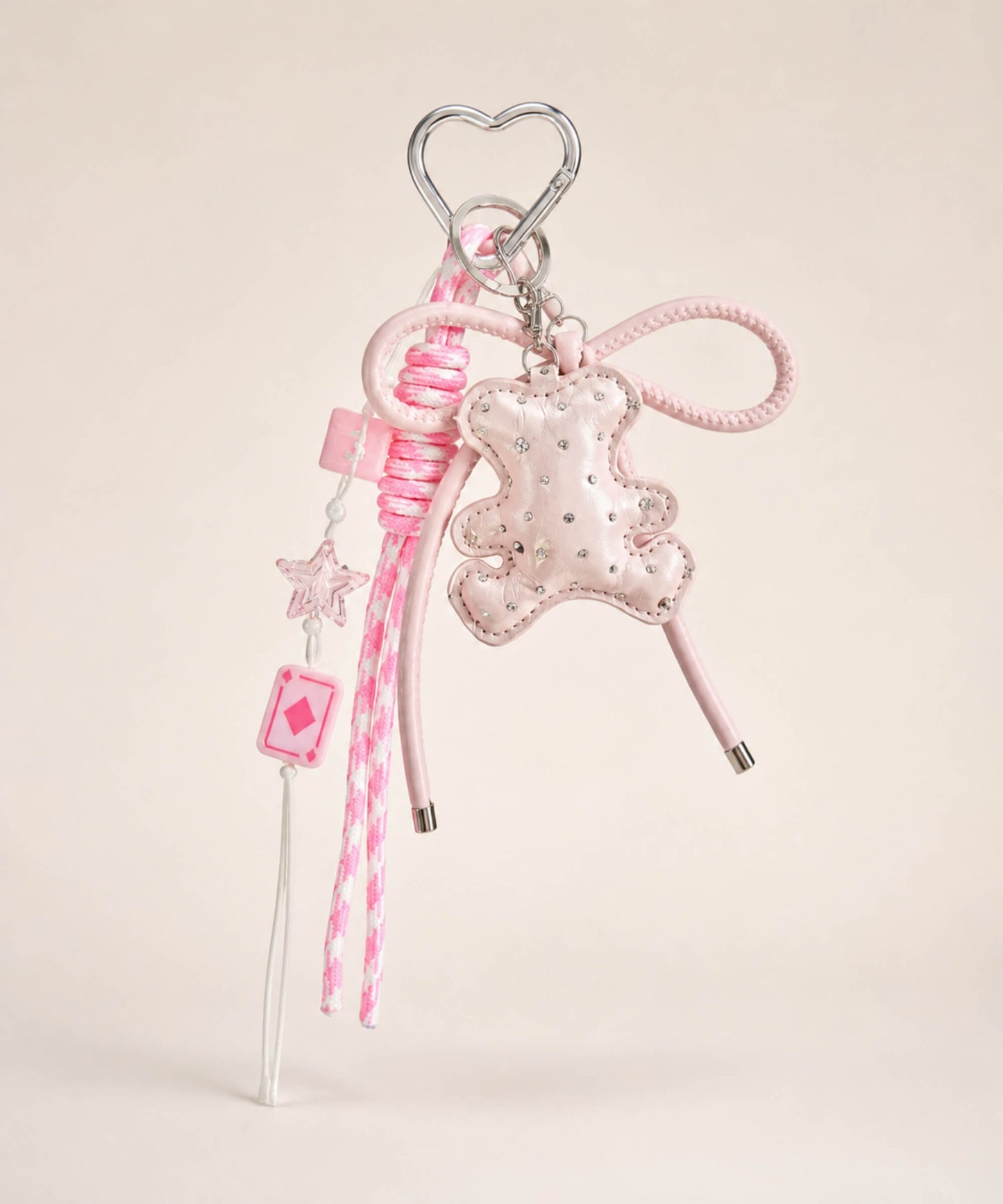 Pink bear PU leather bag charm keychain with a sparkle charm, star charm and card charm on a neutral background.