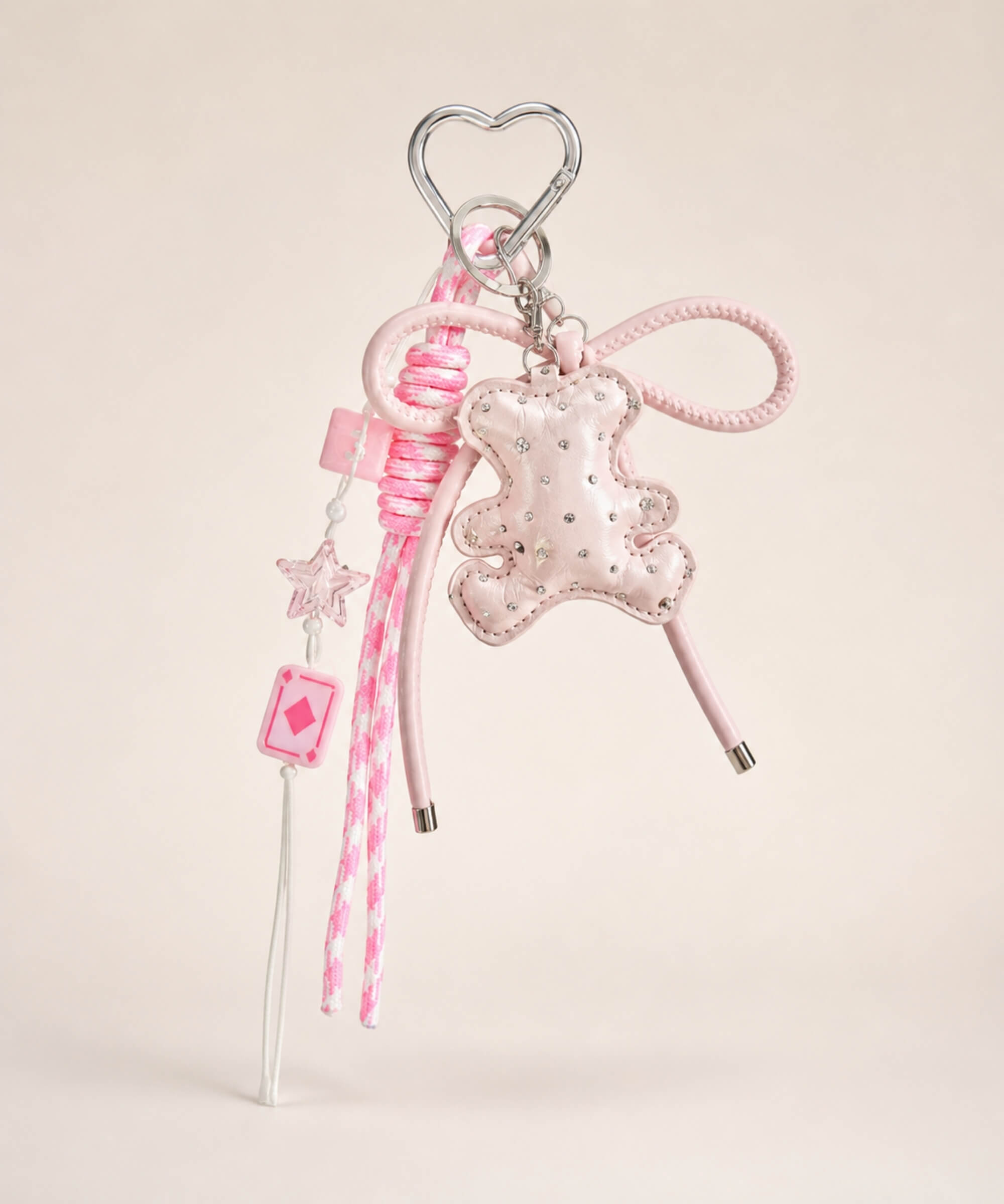 Pink bear PU leather bag charm keychain with a sparkle charm, star charm and card charm on a neutral background.