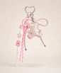 Pink bear PU leather bag charm keychain with a sparkle charm, star charm and card charm on a neutral background.