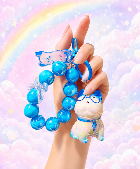 Blue French Bulldog beaded keychain held in hand with a pastel rainbow background