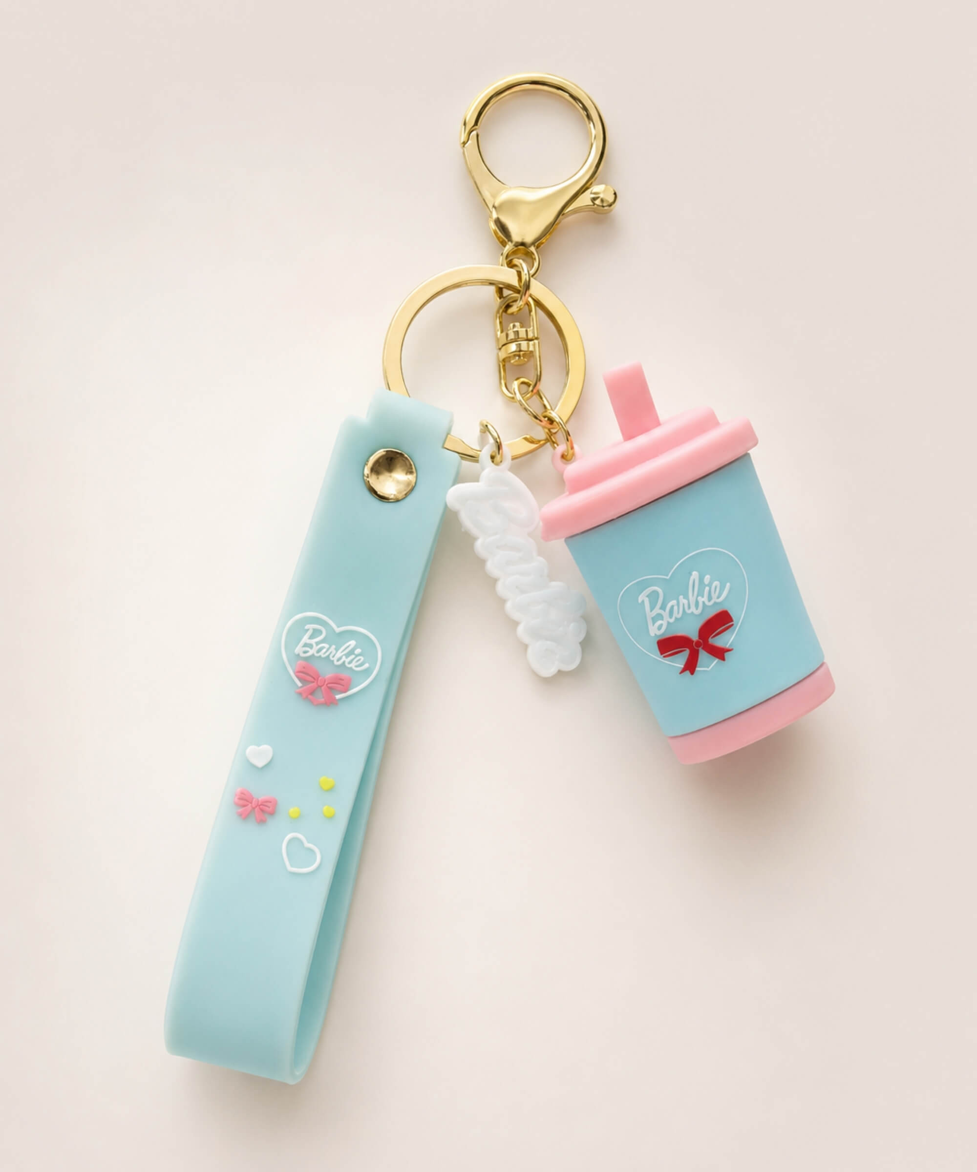 Blue sippy cup keychain with blue strap, pink lid, white gummy charm and gold hardware