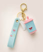 Blue sippy cup keychain with blue strap, pink lid, white gummy charm and gold hardware