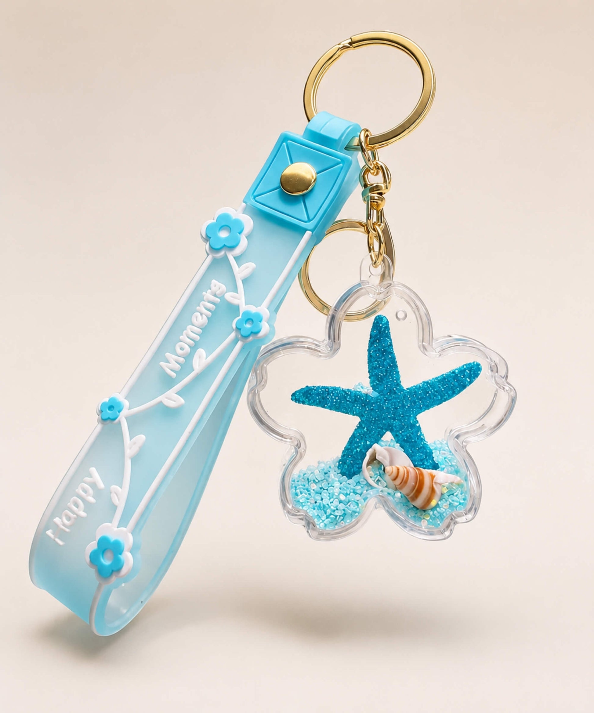 Blue starfish liquid keychain with blue glitter, shell detail, floral strap and gold hardware