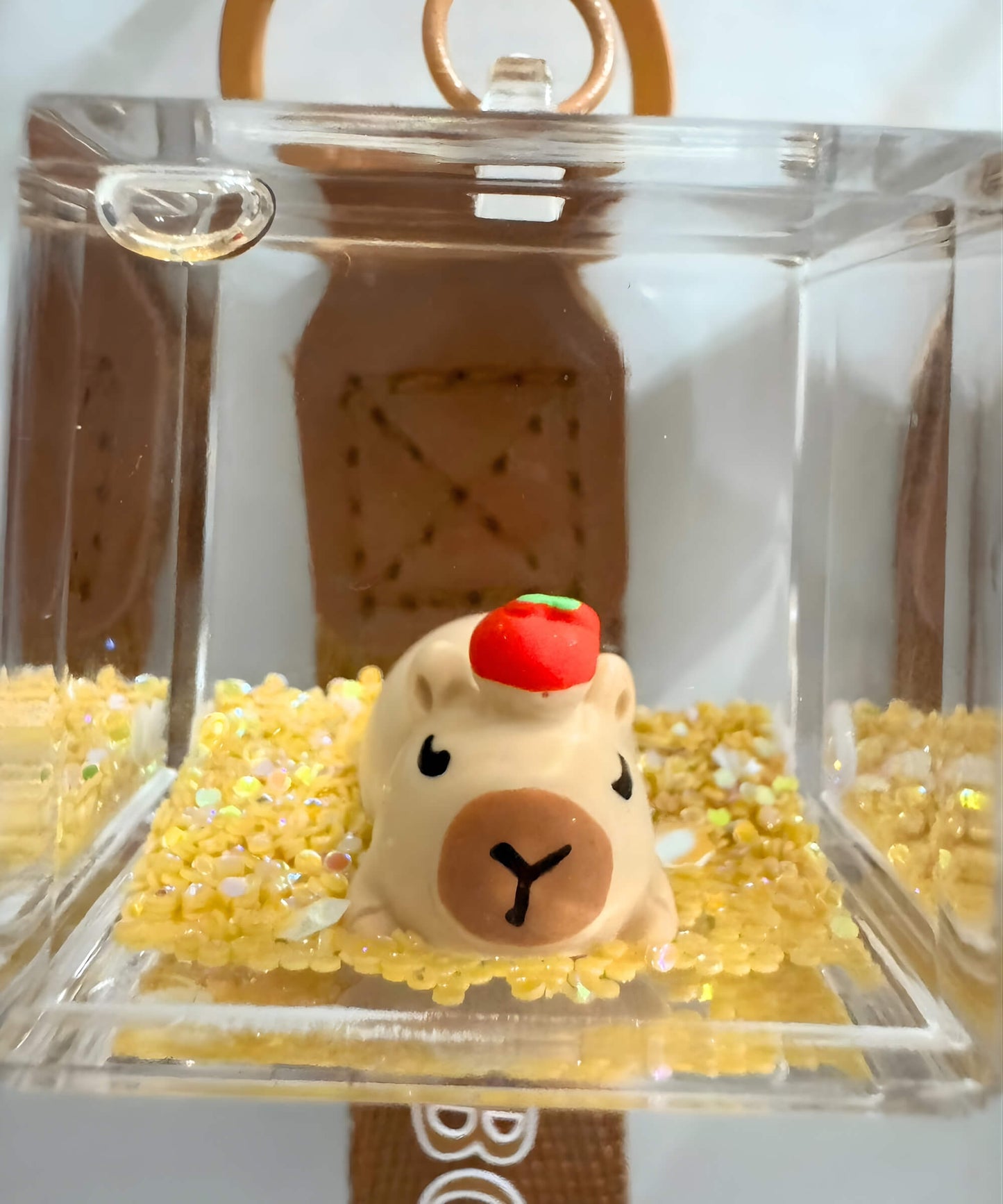 Close up of capybara liquid keychain with acrylic cube and glitter movement