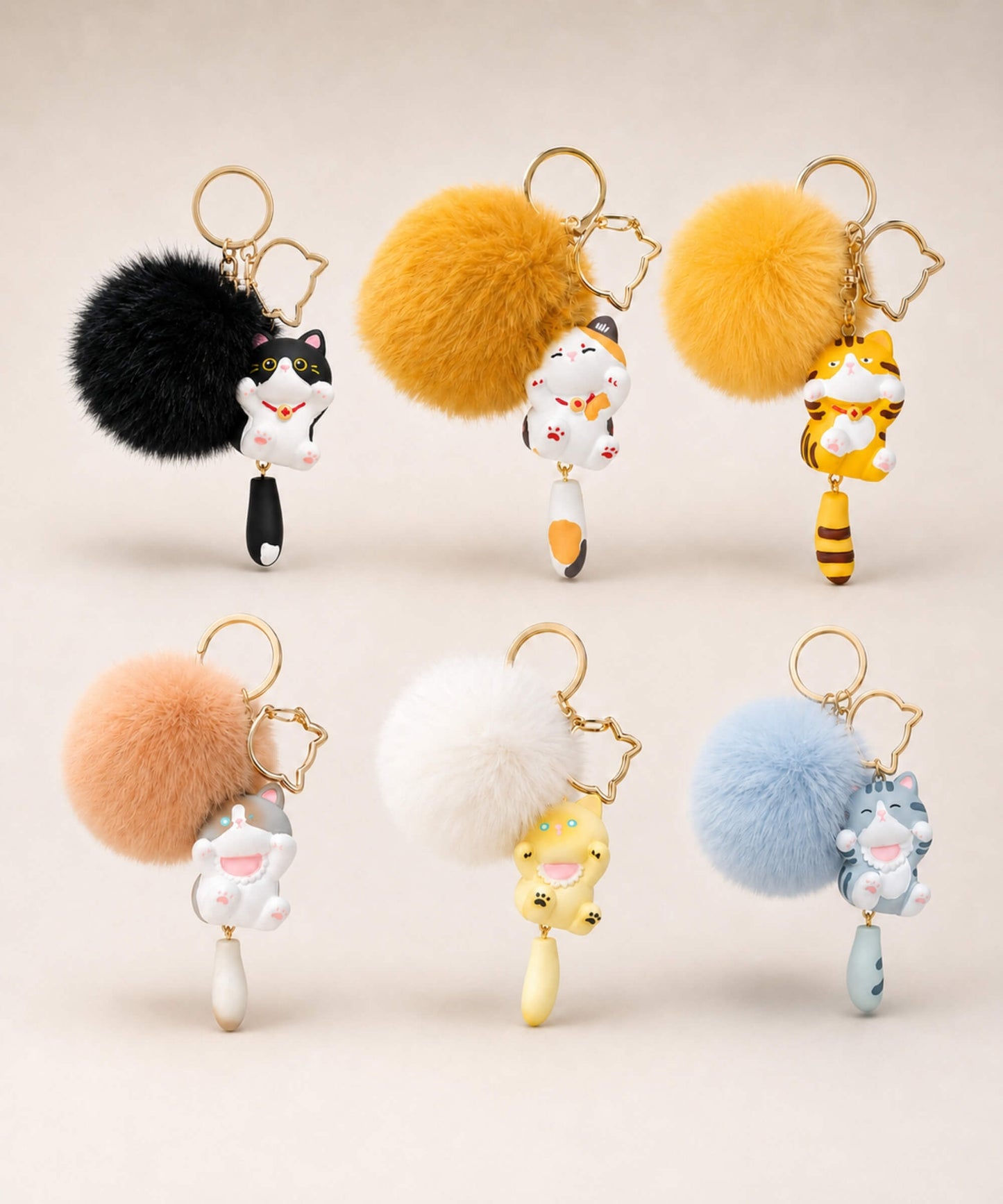 Cat pom pom resin keychains in assorted colour options displayed together on a neutral background