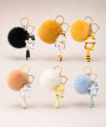 Cat pom pom resin keychains in assorted colour options displayed together on a neutral background