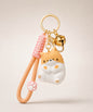 Orange chubby cat resin keychain on a neutral background.