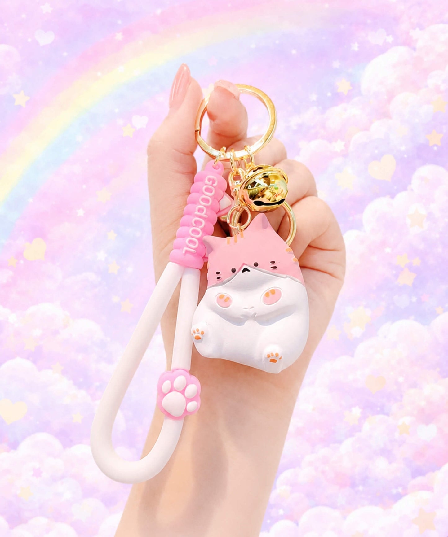 Hand holding a pink chubby cat resin keychain against a pastel rainbow background.