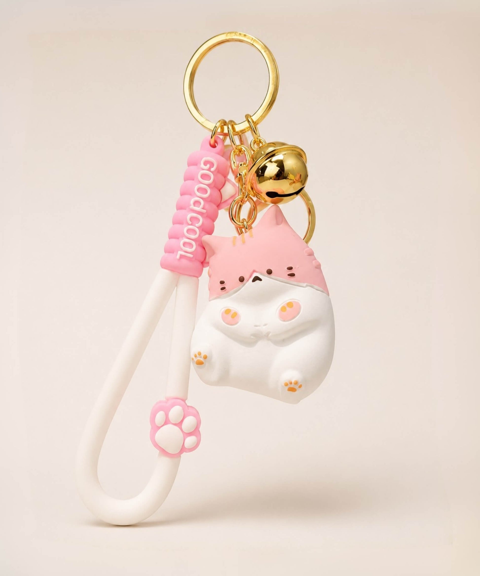 Pink chubby cat resin keychain on a neutral background.