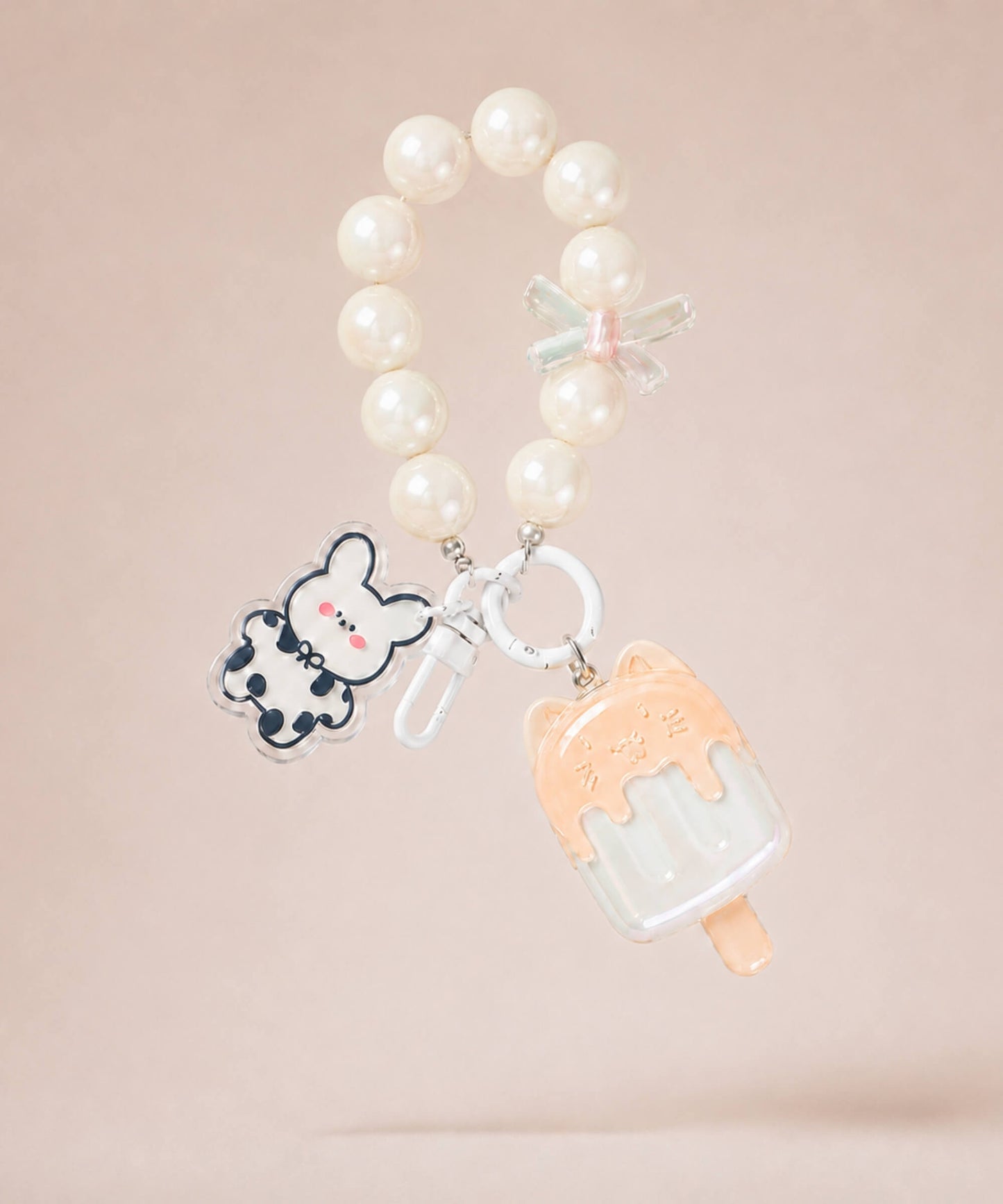 White ice cream beaded keychain with pearl-style beads and bunny charm on a neutral background