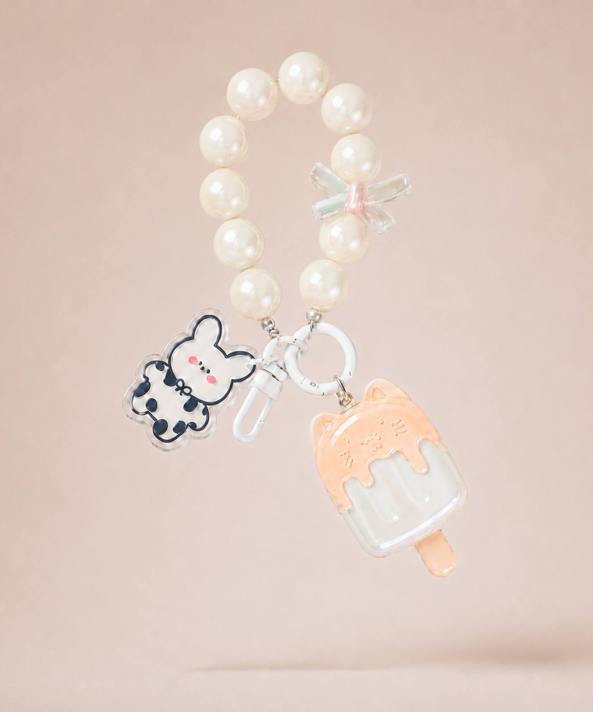White ice cream beaded keychain with pearl-style beads and bunny charm on a neutral background