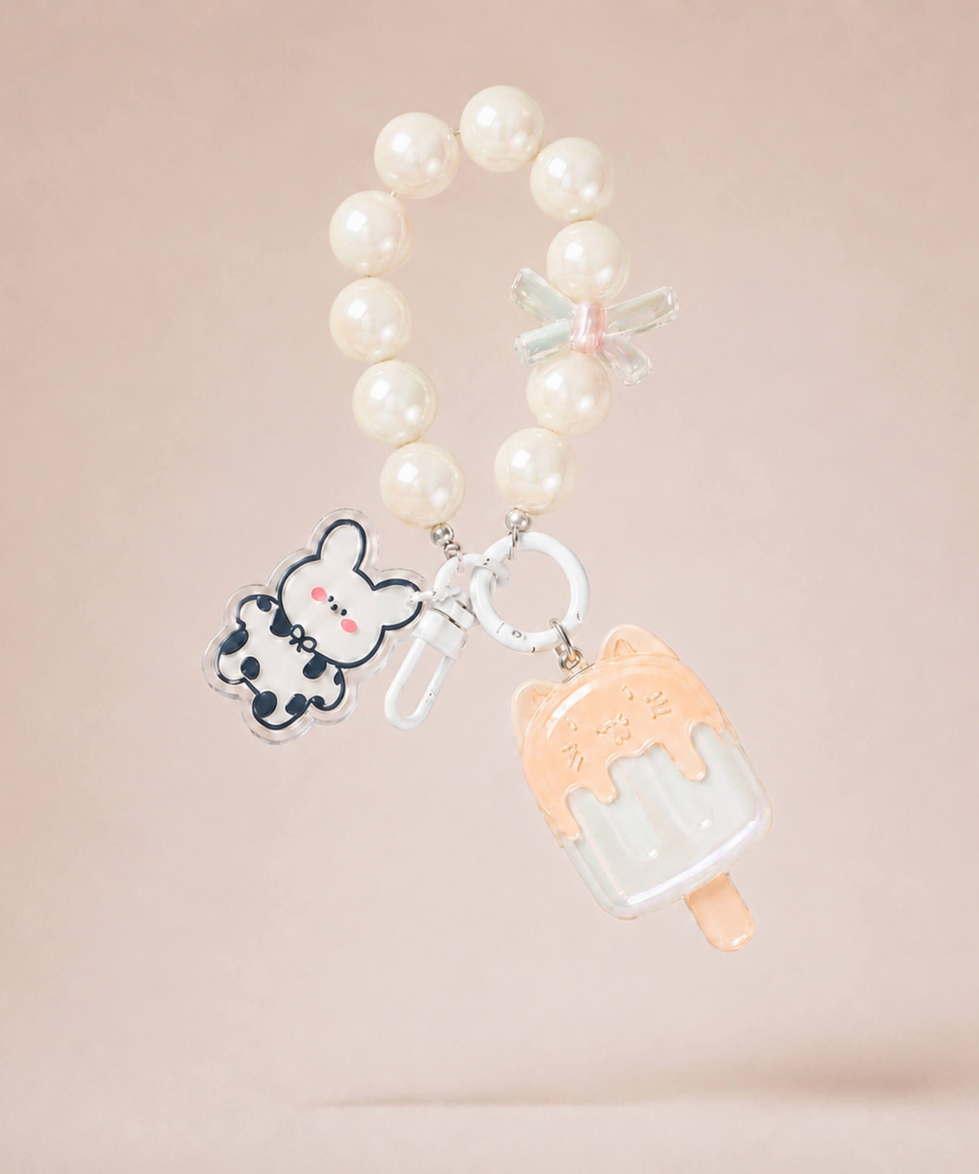 White ice cream beaded keychain with pearl-style beads and bunny charm on a neutral background