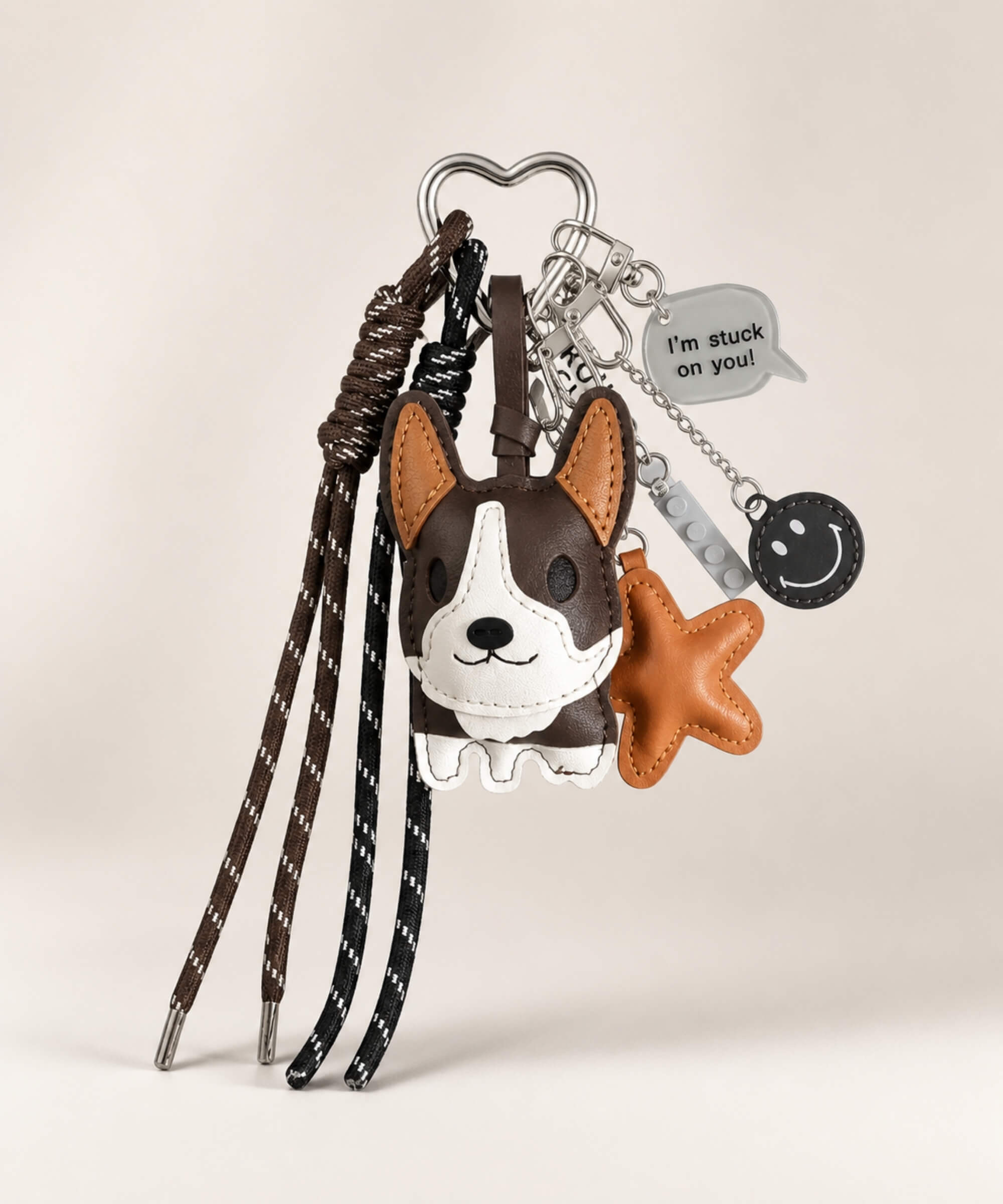 Dark brown Cute Corgi faux leather bag charm keychain with tassel cords and decorative charms on a clean neutral background.