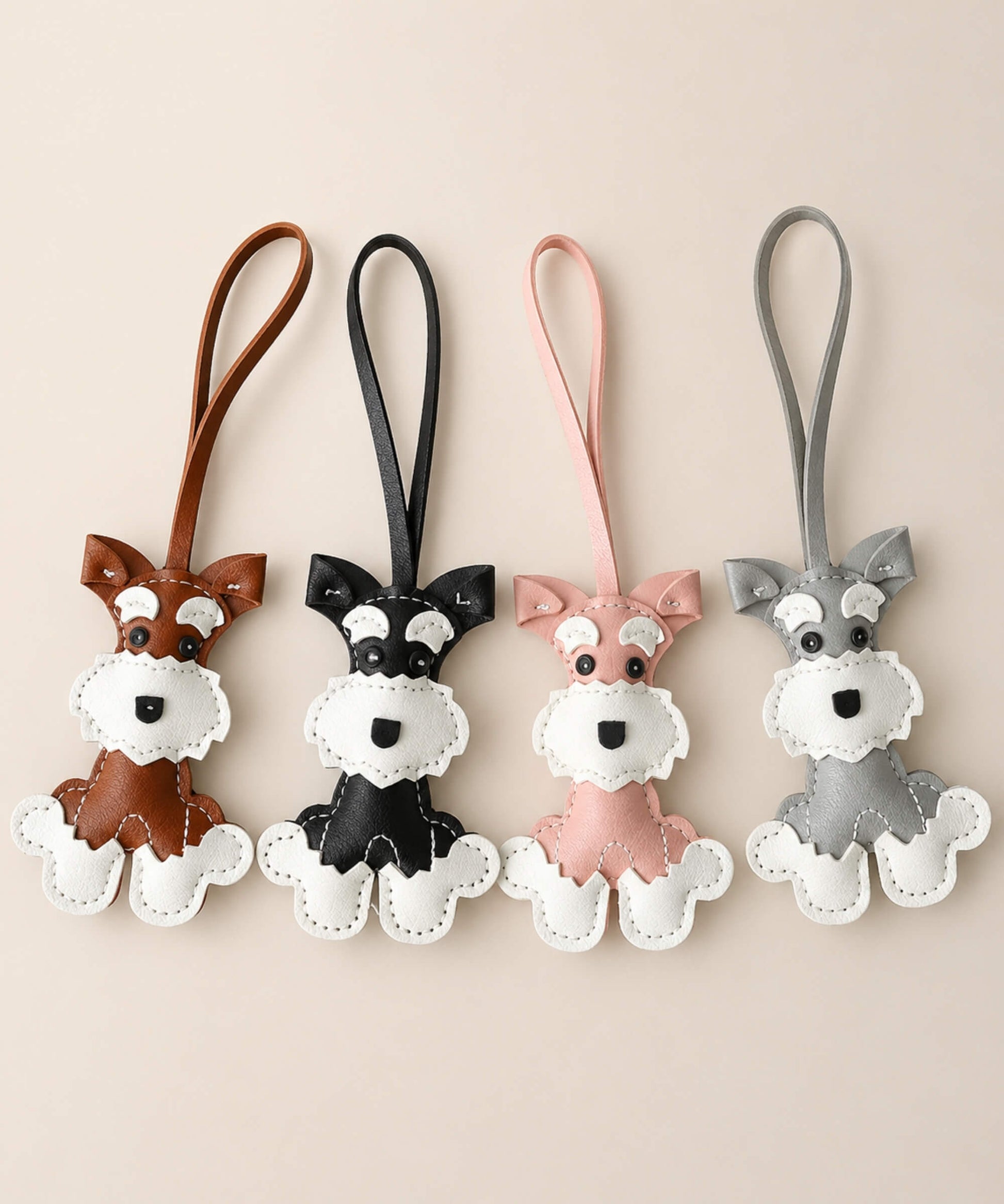 Cute Schnauzer faux leather bag charm keychains in brown, black, pink and grey on a clean neutral background.