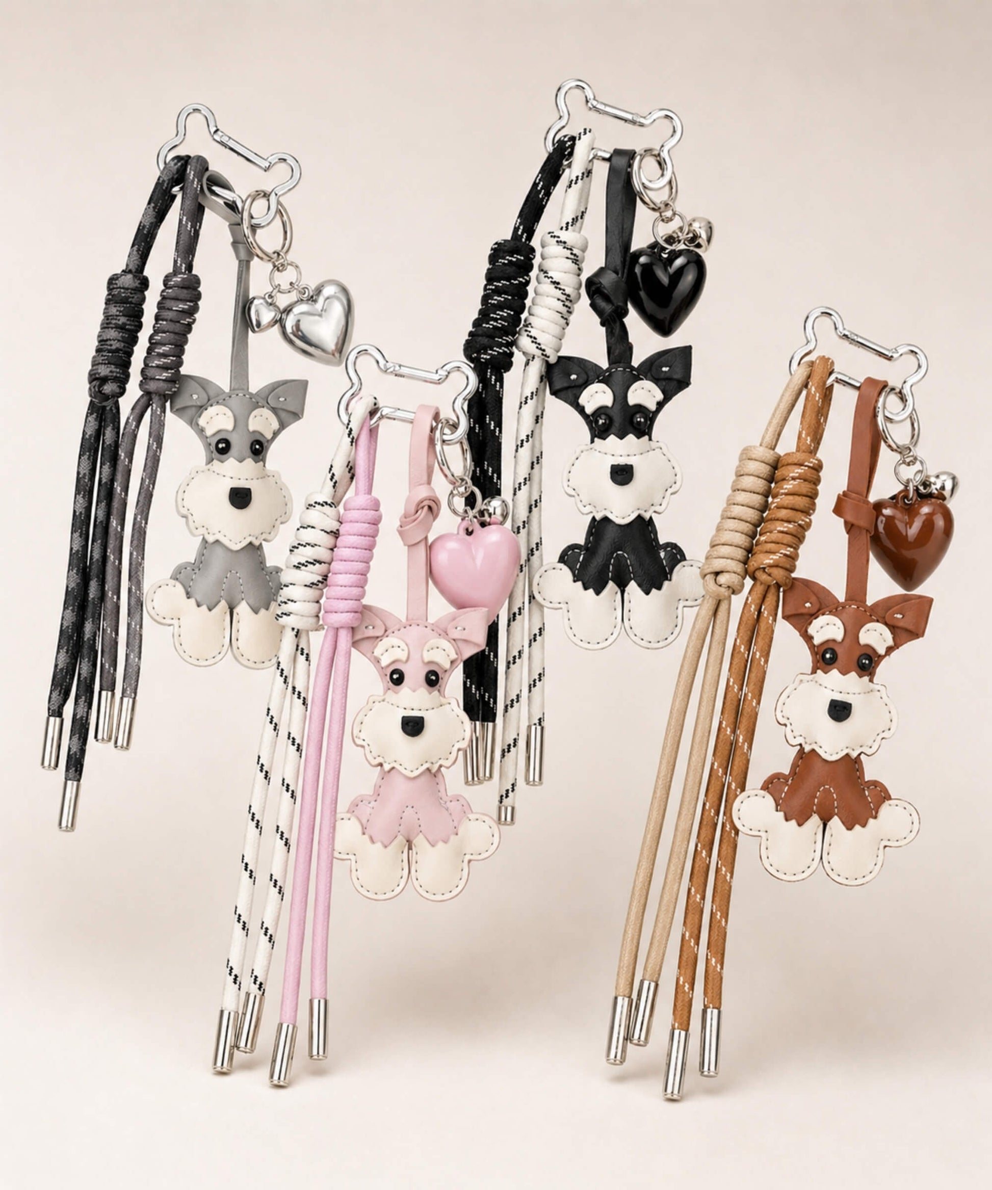 Cute Schnauzer faux leather bag charms with heart pendants in grey, pink, black and brown on a clean neutral background.