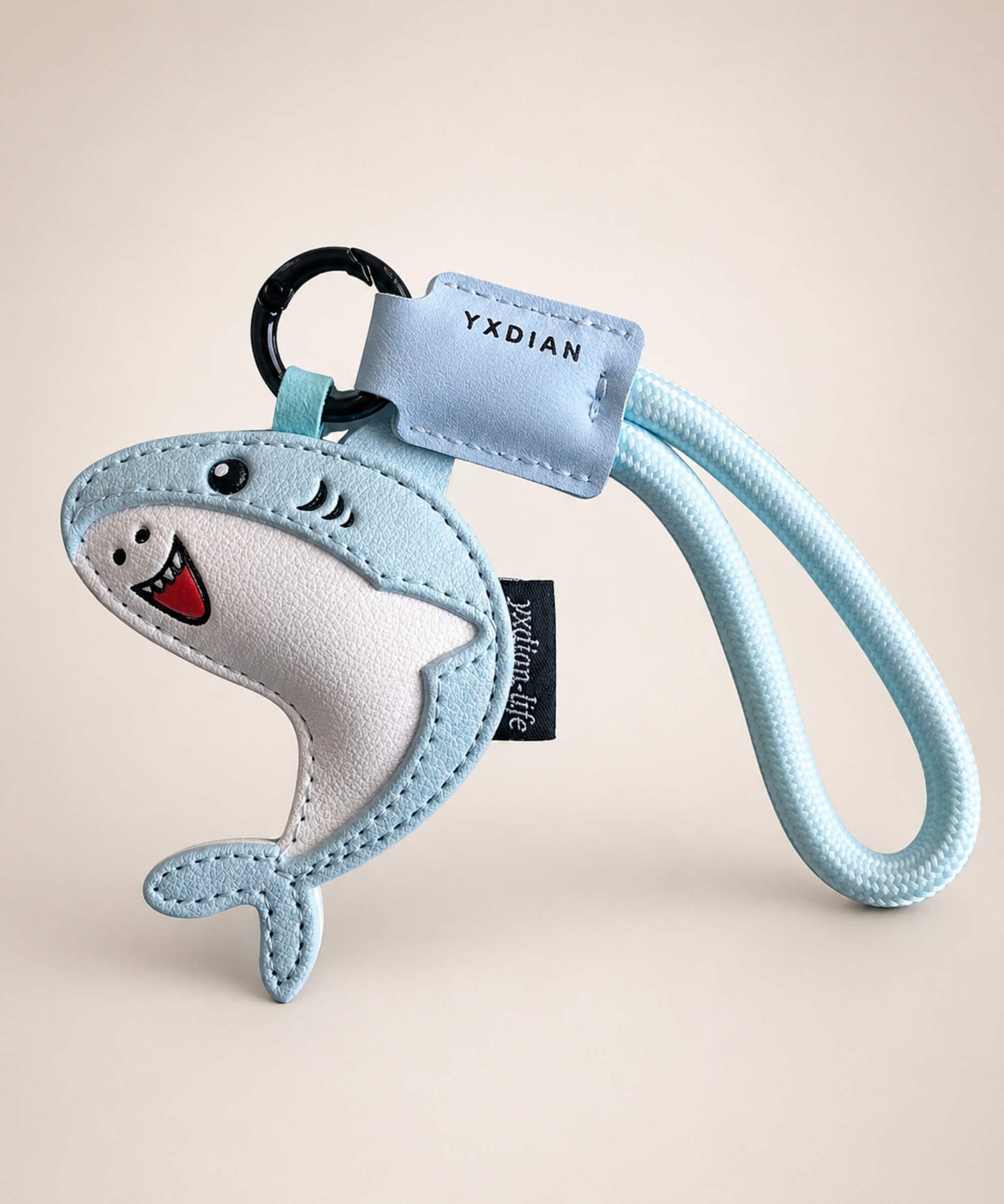Blue cute shark PU leather keychain with wrist strap on a neutral studio background.