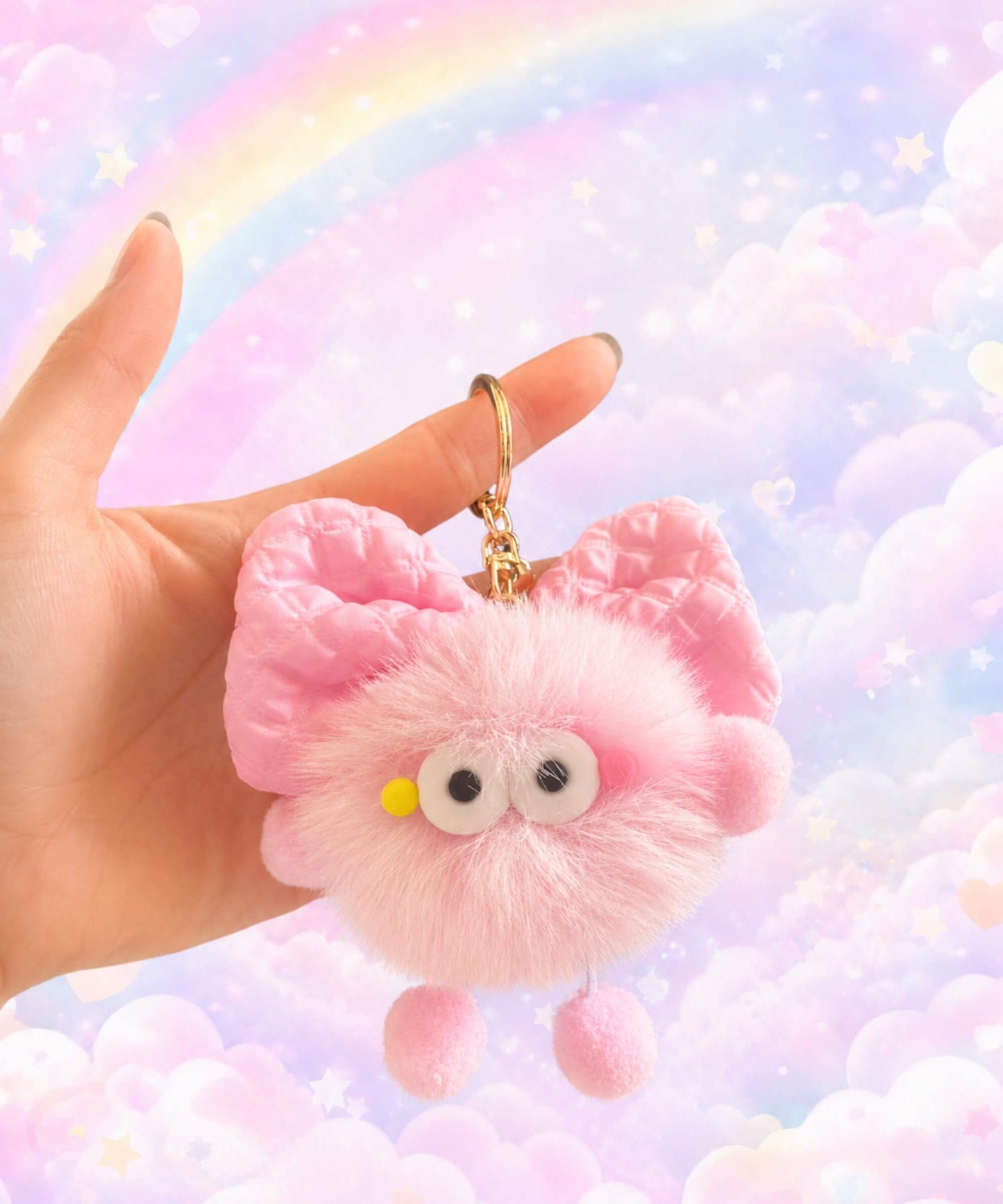 Fluffy bow plush keychain held in hand with soft pink plush texture and pastel rainbow cloud background