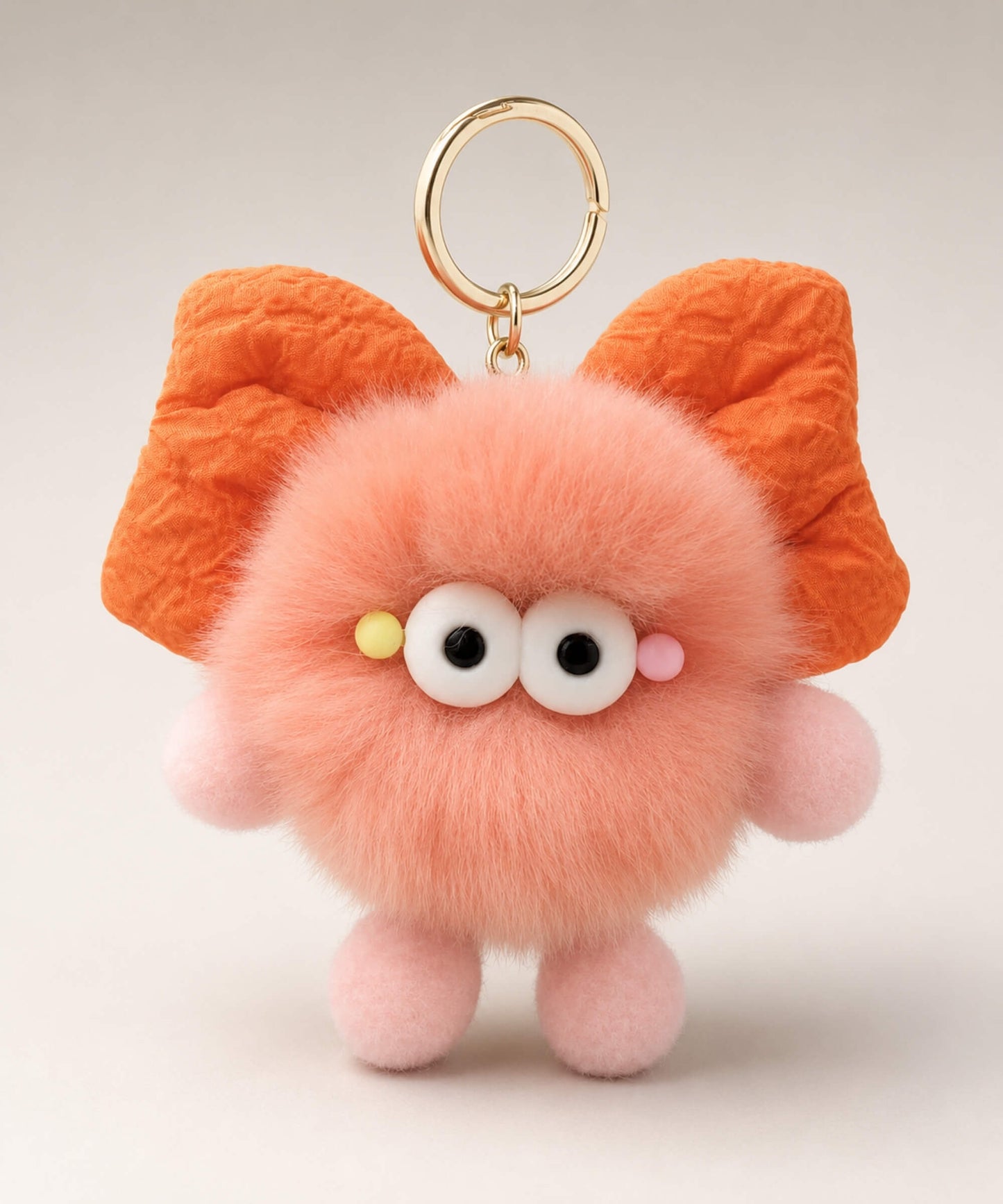 Peach fluffy bow plush keychain with cute wide-eye design and gold-tone key ring