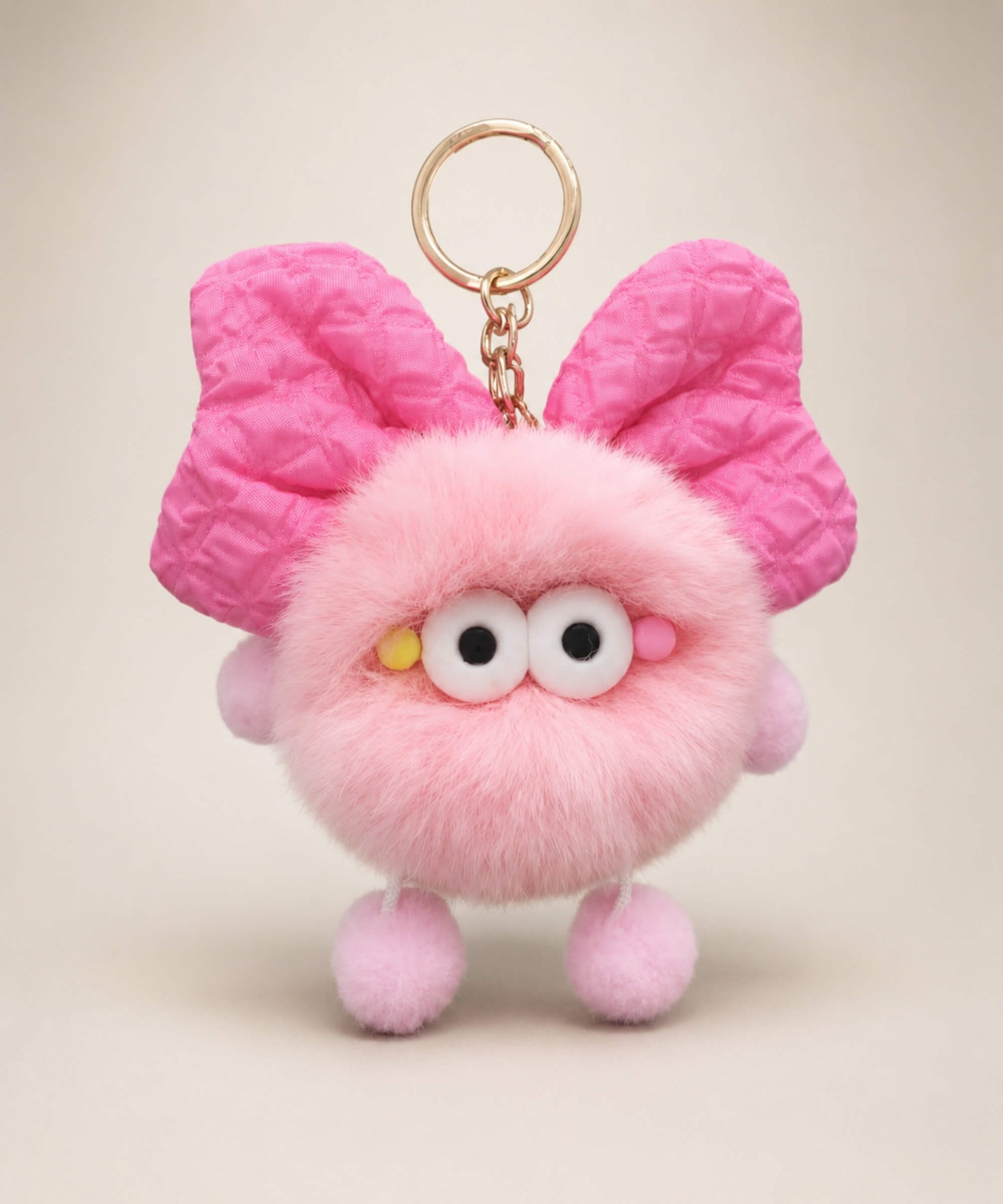 Pink fluffy bow plush keychain with oversized bow-style ears and soft furry texture
