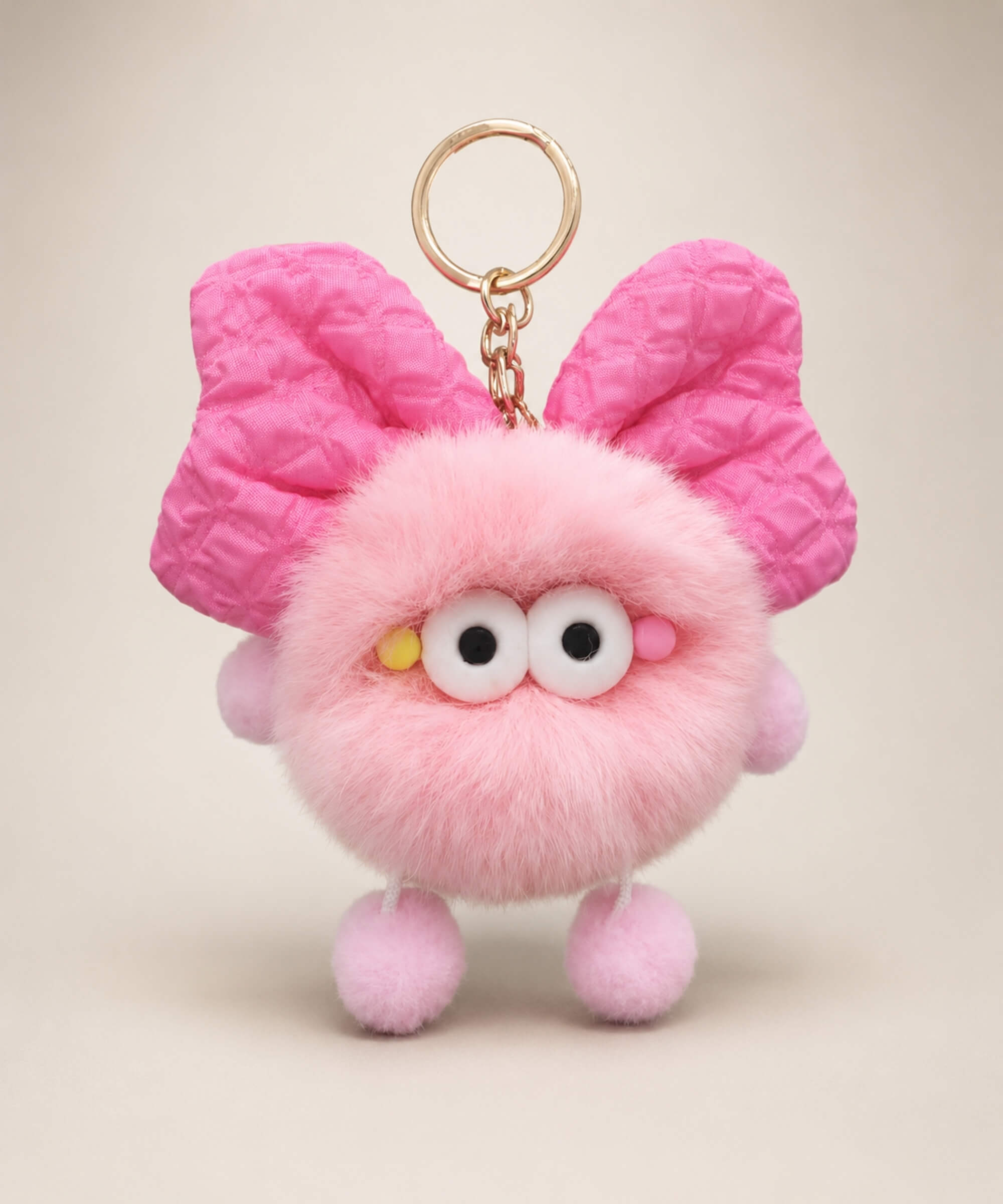 Pink fluffy bow plush keychain with oversized bow-style ears and soft furry texture