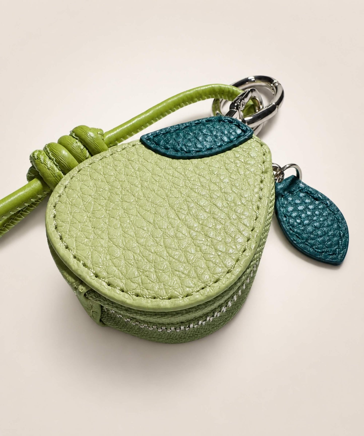 Close-up of avocado fruit coin purse keychain with textured green PU leather-style pouch and leaf detail