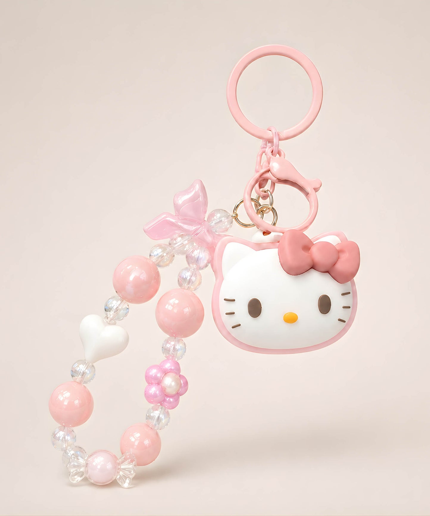 Hello Kitty pink beaded keychain with bow, heart and flower charm details on a neutral background