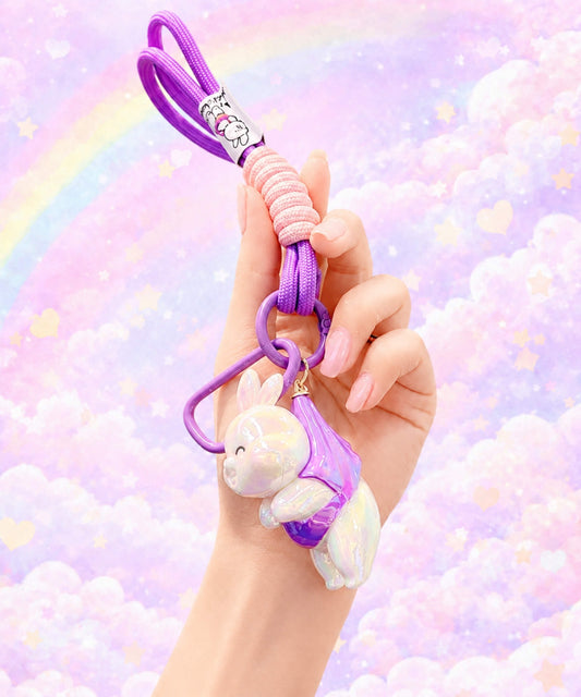 Purple iridescent bunny resin keychain held in hand